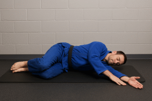 BJJ athlete doing open book thoracic rotation stretch to improve upper-back mobility